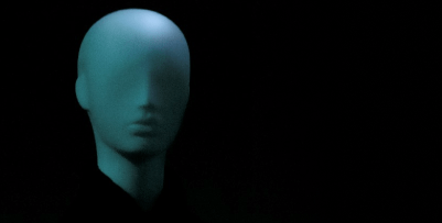 A humanoid figure with abnormally smooth features and no eyes wearing a black outfit. It stares at the viewer.